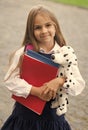 Happy small kid in school uniform hold study books and toy dog friend, friendship Royalty Free Stock Photo