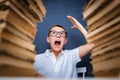 Happy smart boy in glasses sitting between two piles of books and look up smiling Royalty Free Stock Photo
