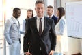 Happy smart business man with team mates discussing in the background. Royalty Free Stock Photo