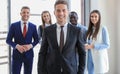 Happy smart business man with team mates discussing in the background. Royalty Free Stock Photo