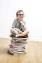 Happy smart child seated on top of books having idea