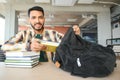 Happy smart indian or arabian guy, mixed race male, university student, stands in the library against the background of Royalty Free Stock Photo