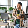 Happy smart indian or arabian guy, mixed race male, university student, stands in the library against the background of Royalty Free Stock Photo