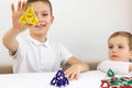 Happy smile boy holding magnet in the hand. Development, fine motor skills and creativity concept