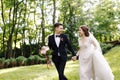 Happy smile bride and groom look at each other and running in the green garden. Wedding in the summer in the park. Happy Royalty Free Stock Photo