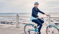 Happy, smile and cycling with old woman at beach for fitness, peace and travel with blue sky mockup. Relax, workout and