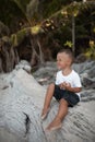 Happy smile european blond baby boy have rest and sit on white sand beach Royalty Free Stock Photo