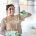 Happy, smile and girl cleaning window with spray bottle and soap or detergent, housekeeper in home or hotel. Housework Royalty Free Stock Photo