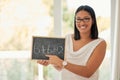 Happy, smile and portrait of a math teacher with a board pointing to an equation in her classroom. Happiness, smart and