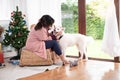 Happy smile woman sitting and hug her lovely white Akita dog in the living room which decorated with the Christmas theme and many Royalty Free Stock Photo