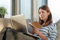 Happy smile young asian woman working with laptop and hold pen with notebook and sitting on sofa at home office, Selective focus Royalty Free Stock Photo