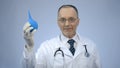 Happy smiled proctology doctor showing rubber syringe and looking at camera Royalty Free Stock Photo