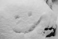 Happy smiley face drown on a rock covered with a fresh snow