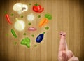 Happy smiley face fingers looking at illustration of colorful healthy vegetables Royalty Free Stock Photo