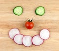 Happy smiley made from red tomato, radish and cucumbers circles Royalty Free Stock Photo