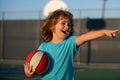 Happy smilin kid playing basketball, pointing showing gesture. Activity and sport for kids. Royalty Free Stock Photo