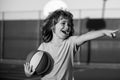 Happy smilin kid playing basketball, pointing showing gesture. Activity and sport for kids. Royalty Free Stock Photo