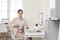 Happy smiling accountant sitting at office desk with laptop and desktop computers Royalty Free Stock Photo