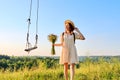 Happy smiling adult woman in dress with hat with a bouquet of wildflowers. Royalty Free Stock Photo