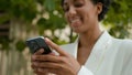 Happy smiling African American businesswoman chatting in social media with mobile app outdoors waiting meeting taxi Royalty Free Stock Photo