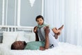 Happy smiling African american dad with baby son on bed at home cuddling and playing, happy family, father`s day Royalty Free Stock Photo