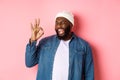 Happy smiling african american man showing okay sign, approve and praise good offer, standing over pink background Royalty Free Stock Photo