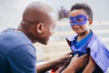 Happy smiling African American son being supported and helped by supportive father Royalty Free Stock Photo