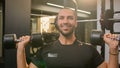 Happy smiling African American sportsman doing power exercise at gym with sport equipment bodybuilder man lifting heavy Royalty Free Stock Photo