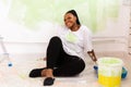 Happy smiling african american woman painting interior wall of new house. Redecoration, renovation, apartment repair and Royalty Free Stock Photo