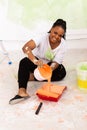 Happy smiling african american woman painting interior wall of new house. Redecoration, renovation, apartment repair and Royalty Free Stock Photo