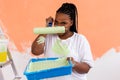 Angry african american woman painting interior wall of new house. Redecoration, renovation, apartment repair and Royalty Free Stock Photo