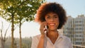 Happy smiling African American woman talking mobile phone smile laughing walking in park outdoors speaking cellphone Royalty Free Stock Photo