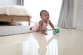 Happy smiling African cute toddle baby infant kid holding toy while crawling on floor in bedroom at home. Happy child with Royalty Free Stock Photo