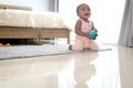 Happy smiling African cute toddle baby infant kid holding toy while crawling on floor in bedroom at home. Happy child with Royalty Free Stock Photo