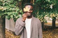 Happy smiling african man holds in hand yellow maple leaves