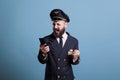 Happy smiling airplane pilot in uniform holding modern phone