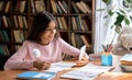 Happy smiling arab schoolgirl using phone for virtual online study at home. Royalty Free Stock Photo