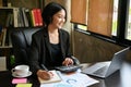 Happy Asian businesswoman is satisfied with her business income while calculating sales Royalty Free Stock Photo