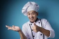 Happy Smiling Asian Chef Pointing Presenting Something on His Empty Hand Royalty Free Stock Photo