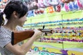 Happy smiling asian child girl holding wooden gun,aim to the point,shooting the target,female playing shooting games for a Royalty Free Stock Photo