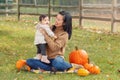 Happy smiling Asian Chinese mother with cute adorable baby. Mom and a daughter girl family sitting in autumn fall park outdoor Royalty Free Stock Photo