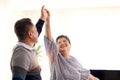 Happy smiling Asian elderly couple dancing in living room, romantic senior lover having fun together at home, mature retired Royalty Free Stock Photo