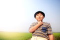Happy smiling Asian fat boy Wearing a hat standing in a meadow. Royalty Free Stock Photo