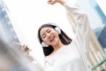 Happy smiling Asian girl listening to music on headphones