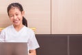 Happy smiling asian girl using notebook computer to study on her Royalty Free Stock Photo