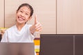 Happy smiling asian girl using notebook computer to study in her Royalty Free Stock Photo