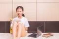 Happy smiling asian girl using tablet computer to study on her b Royalty Free Stock Photo