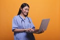 Happy smiling asian healthcare clinic nurse wearing stethoscope and using modern laptop. Royalty Free Stock Photo