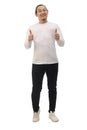 Happy smiling Asian man wearing white shirt and black jeans looking at camera and shows thumbs up, isolated cut out full length