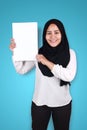 Happy smiling Asian muslim woman looaking at camera while showing blank empty white paper Royalty Free Stock Photo